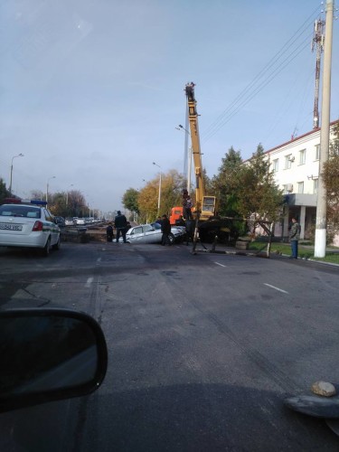 Из ямы достают упавшую в нее машину